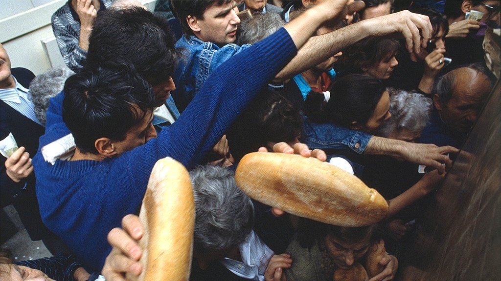 People crowd together to get their share of rationed food during the siege of Sarajevo, 1992