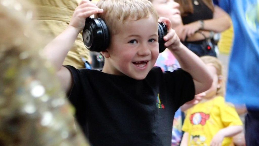 A young blonde boy in headphones