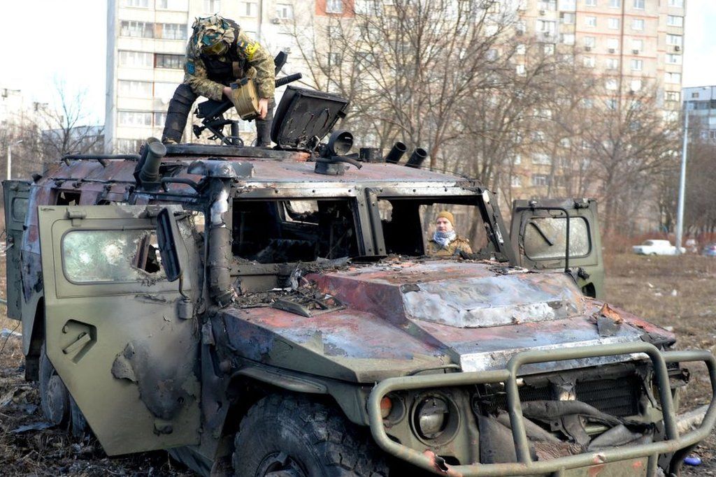 An Ukrainian Territorial Defence fighter examines a destroyed Russian infantry mobility vehicle GAZ Tigr after the fight in Kharkiv