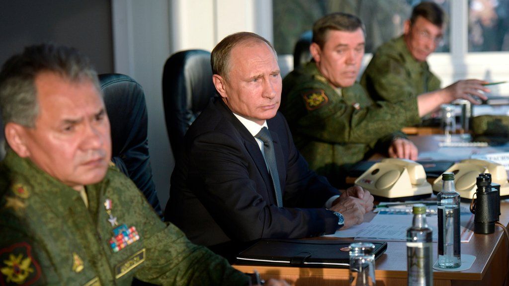 Russian President Vladimir Putin flanked by Defense Minister Sergei Shoigu, left, and Chief of the General Staff of the Russian Armed Forces Valery Gerasimov