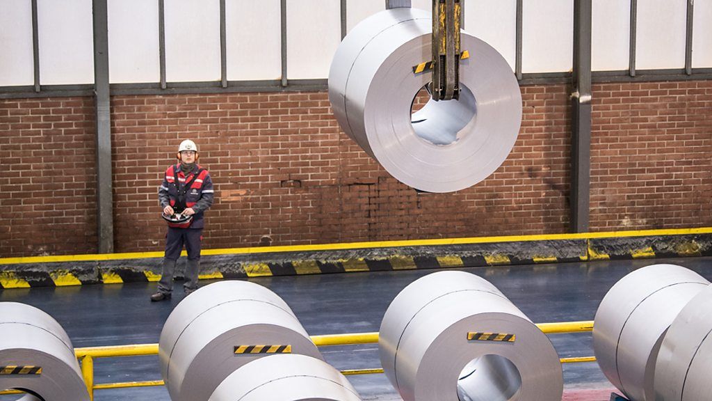 A steelworker moving steel coils