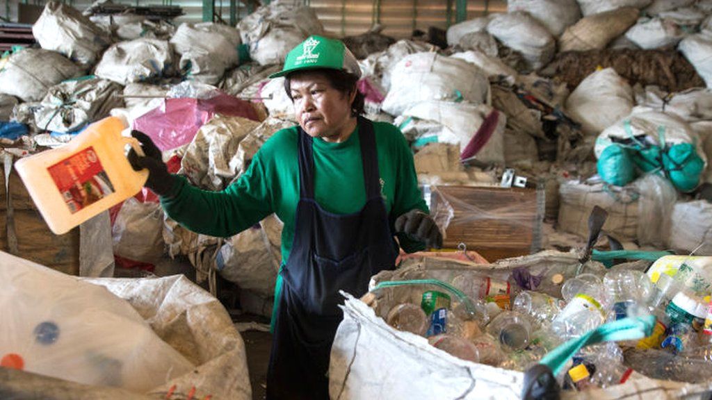 A worker in Thailand separating plastic bottles