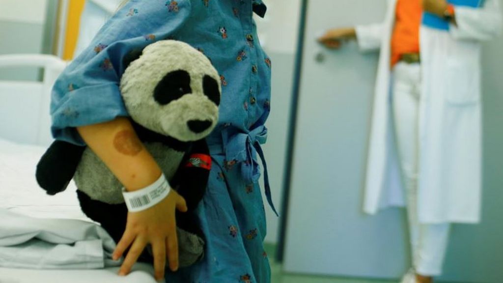 Child with soft panda toy in hospital