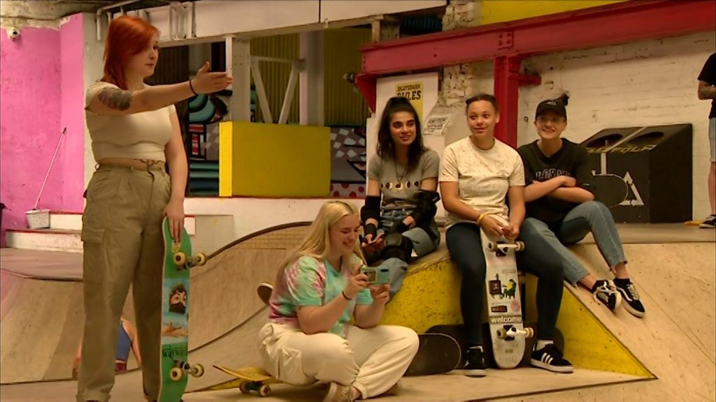 Group of skateboarders sat on skate ramp