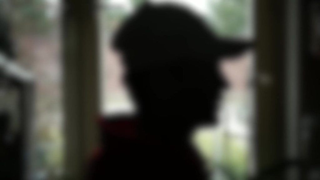 blurred silhouette of man in baseball cap