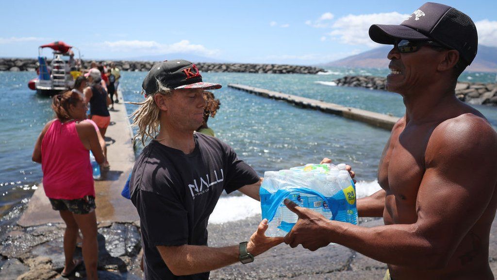 Volunteers load water onto a boat to be transported to West Maui from Kihei