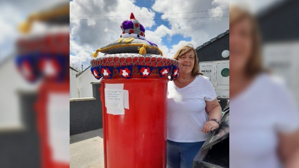Joy Macdonald stood next to her crochet postbox topper