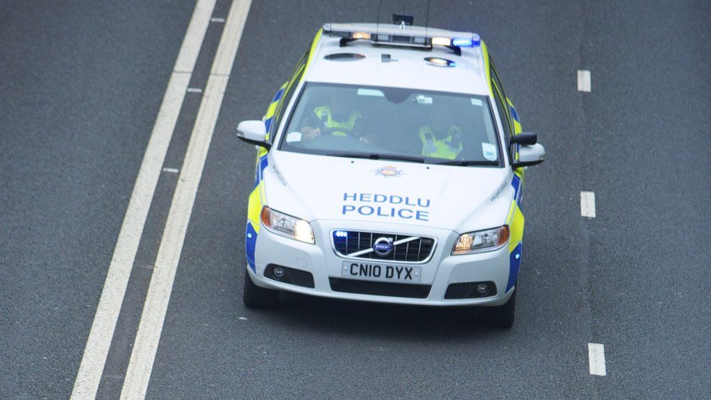 A police car driving along the road