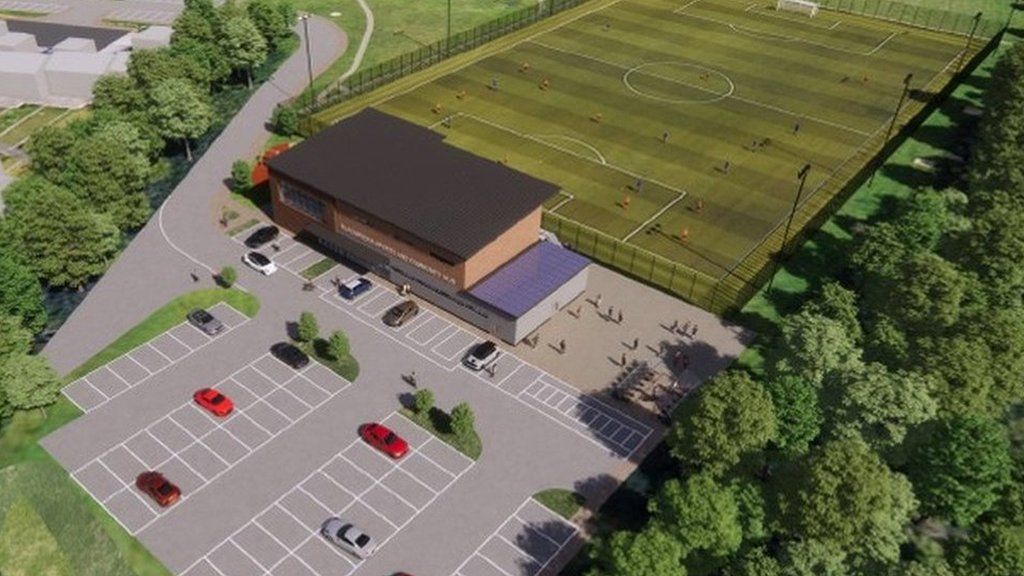 Aerial view of the proposed plans - a car park, building and a football pitch