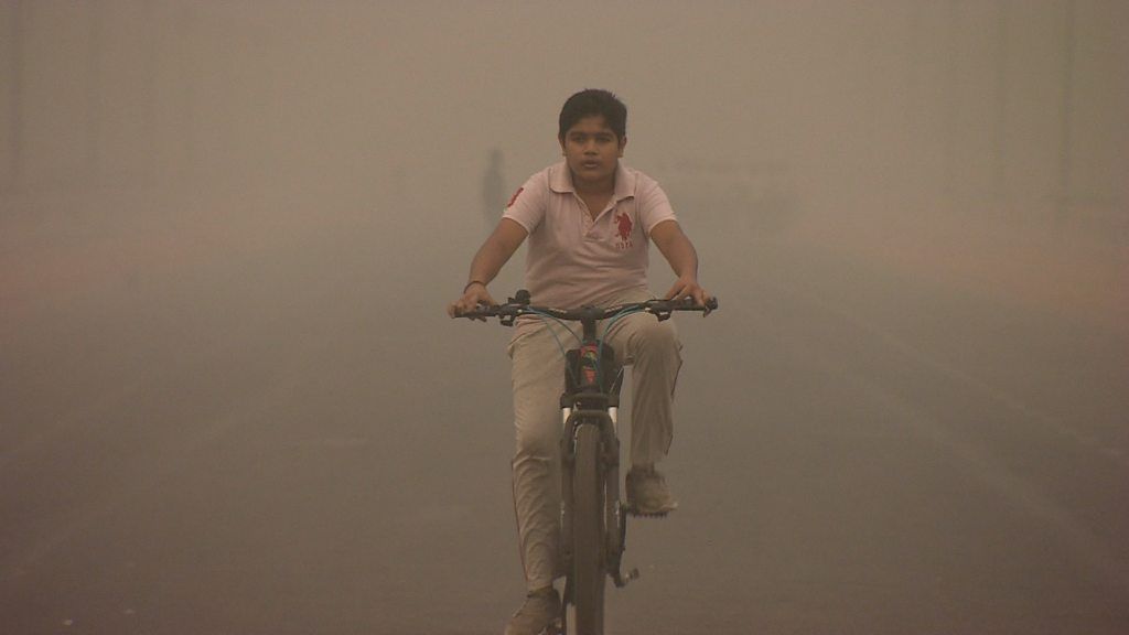 A boy rides a bike in Delhi, India