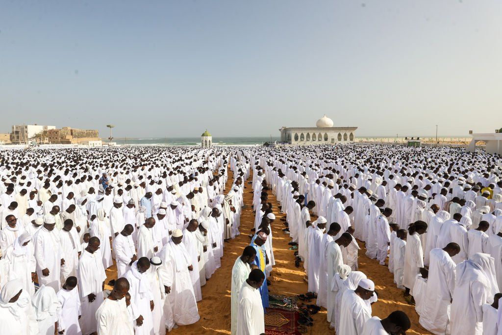 Thousands of Muslims wearing white clothes gather to perform Eid al-Fitr prayer