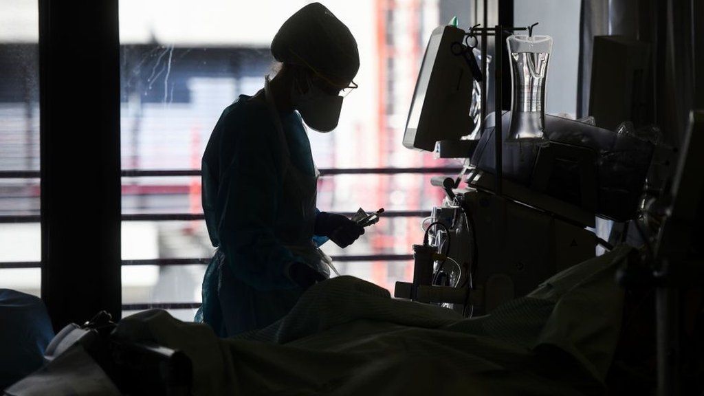 Nurse by a bed in a ICU
