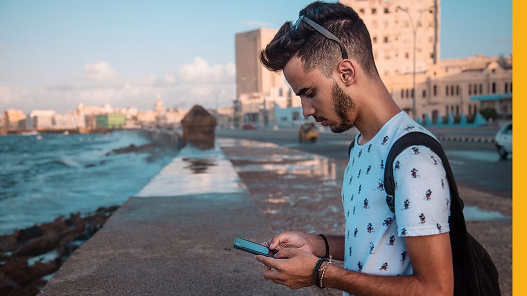 Sergio looking at his mobile phone in Havana