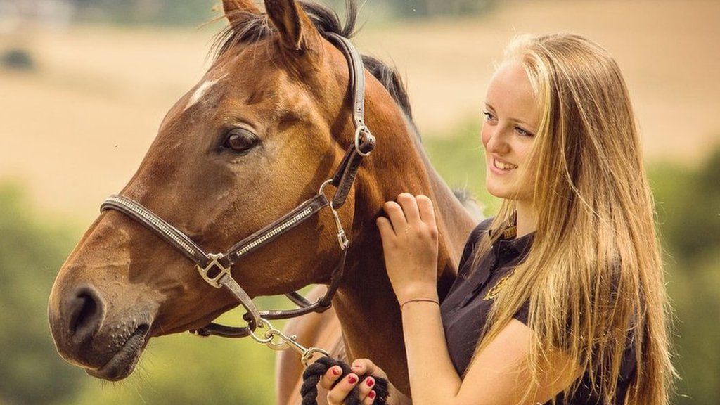 Gracie Spinks in a field with a horse