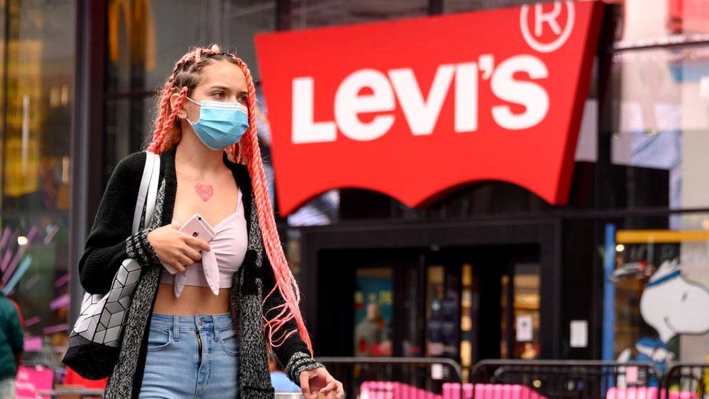 Woman walks in front of the Levi's Times Square store