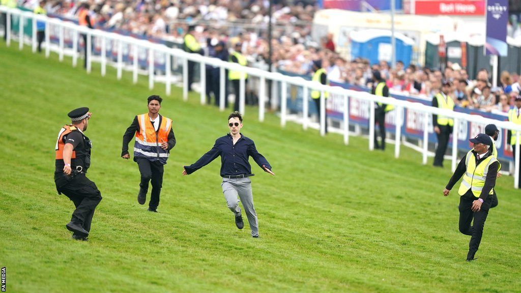 A protestor gets onto the track at Epsom racecourse during the Derby