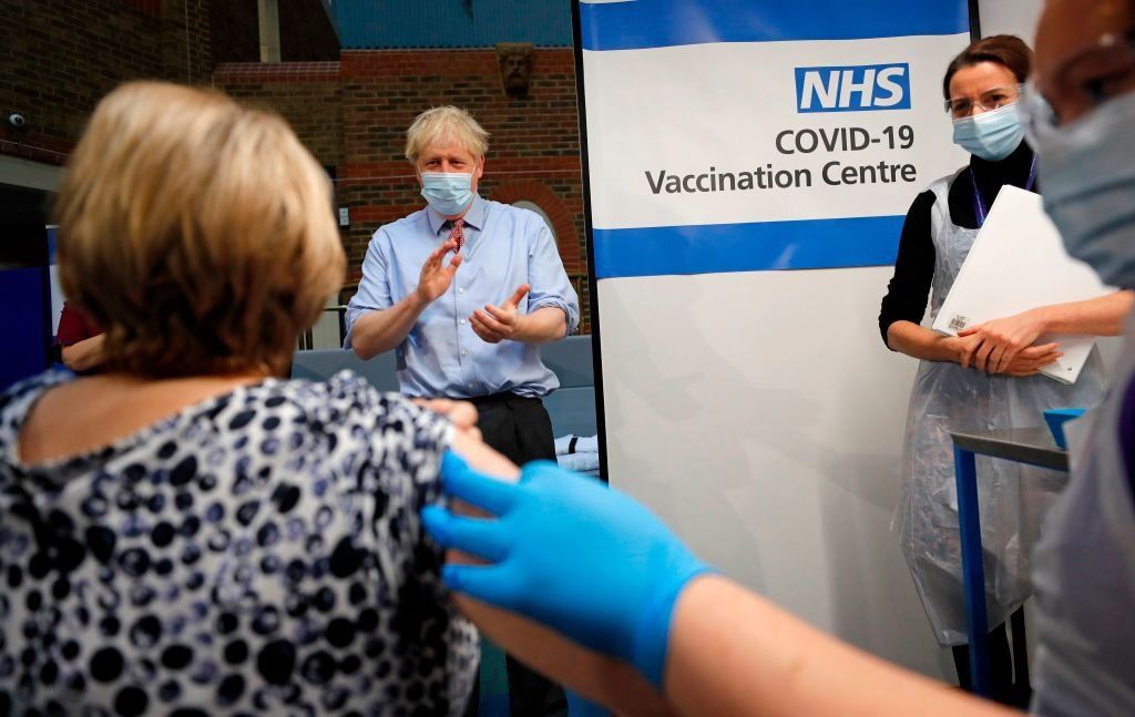 Премьер-министр Великобритании Борис Джонсон аплодирует медсестре Ребекке Катерсайдс, которая ввела вакцину Pfizer-BioNTech COVID-19 Лин Уиллер в больнице Гая в Лондоне