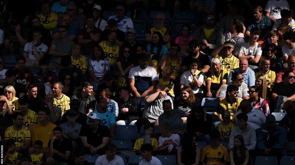 Oxford United fans celebrate in the stands at the Kassam Stadium.