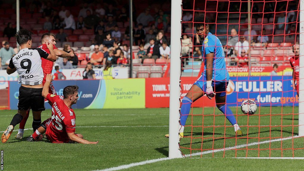 Crawley Town defender Harry Ransom (second left, partially obscured) scores an own goal during their League Two match against Gillingham
