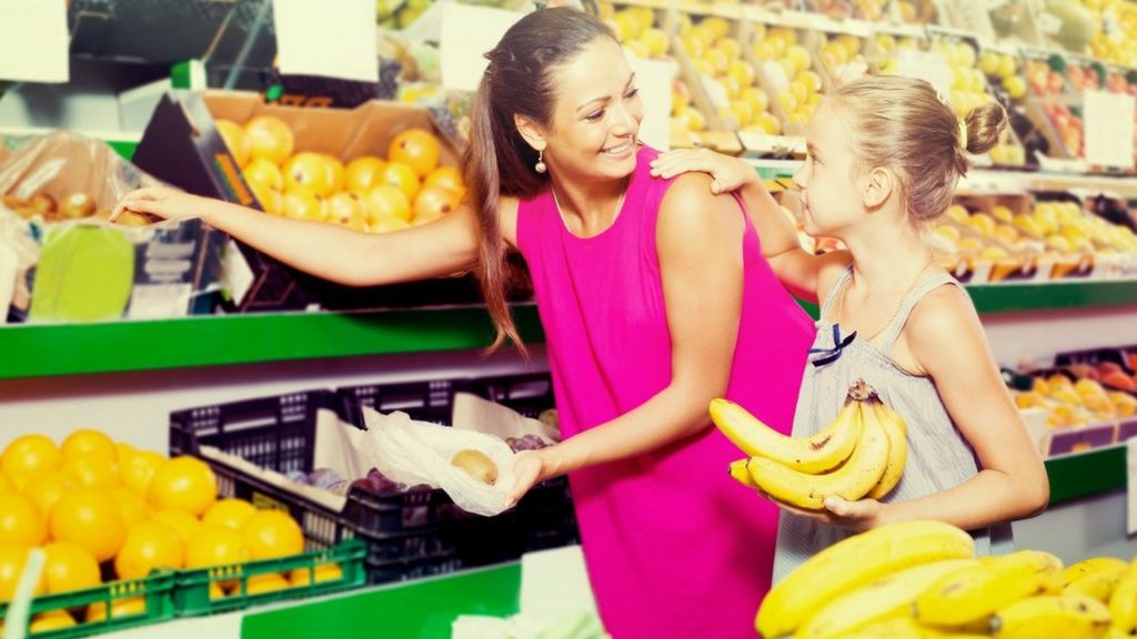 Woman and daughter shopping for bananas