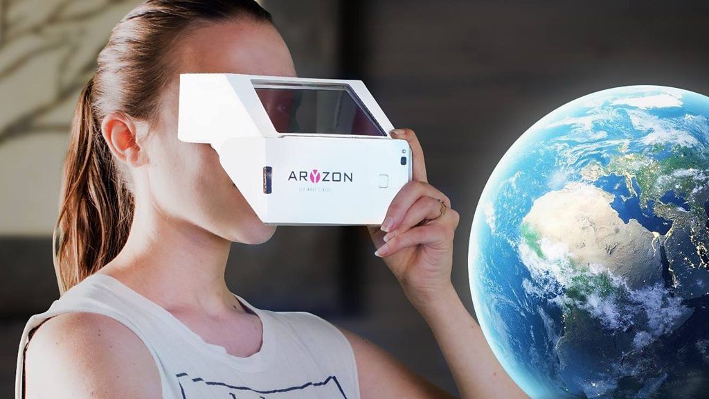 A woman holding up an augmented reality viewer
