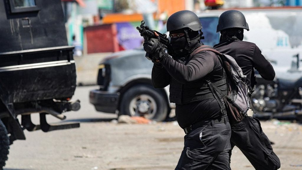 Police officers in military gear hold guns on the streets of Port-au-Prince
