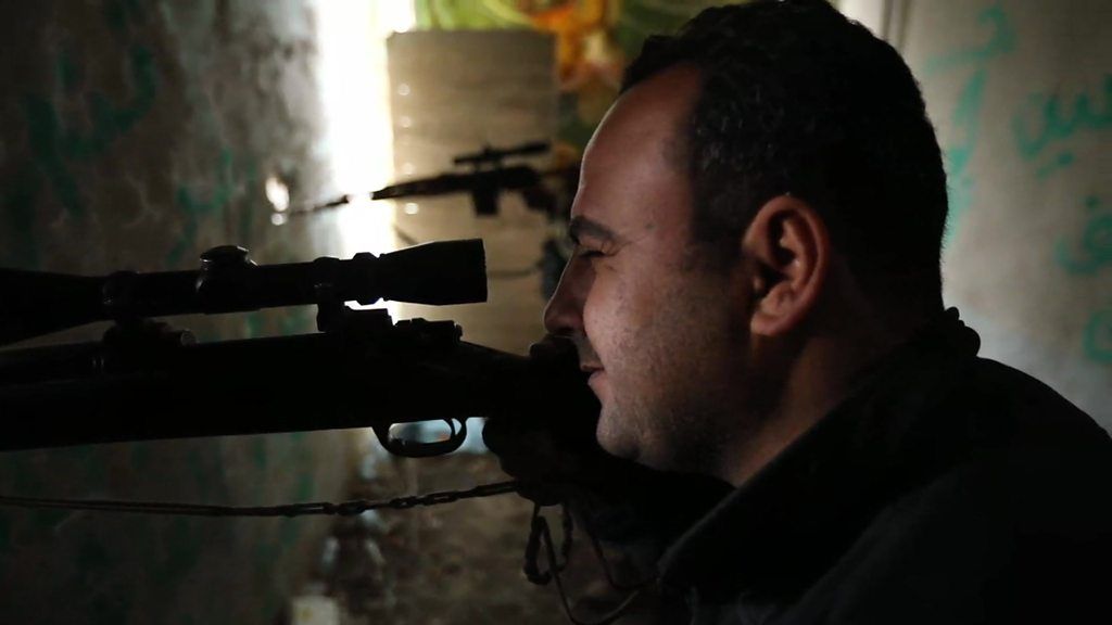 An Iraqi soldier looks through a gun