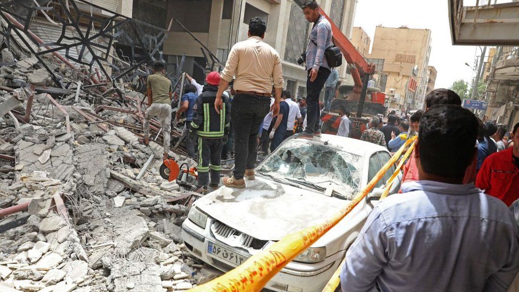 Rescue workers and bystanders search through the rubble of a collapsed building in Abadan, Iran (23 May 2022)