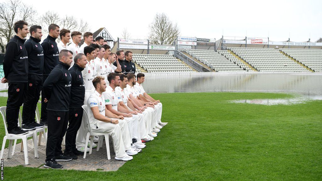 Players line up next to a flooded outfield for a team photograph