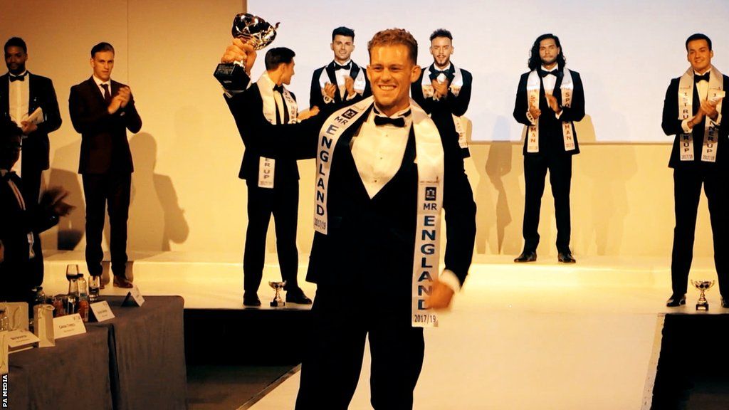 Jack Eyers on the catwalk, holding his Mr England title in 2017