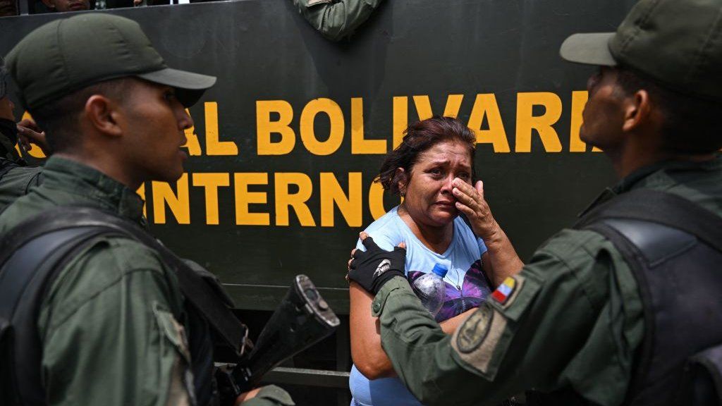 A relative of an inmate is comforted by a member of the Bolivarian National Guard (GNB) after authorities seized control of the Tocoron prison in Tocoron, Aragua State, Venezuela, on September 20, 2023.