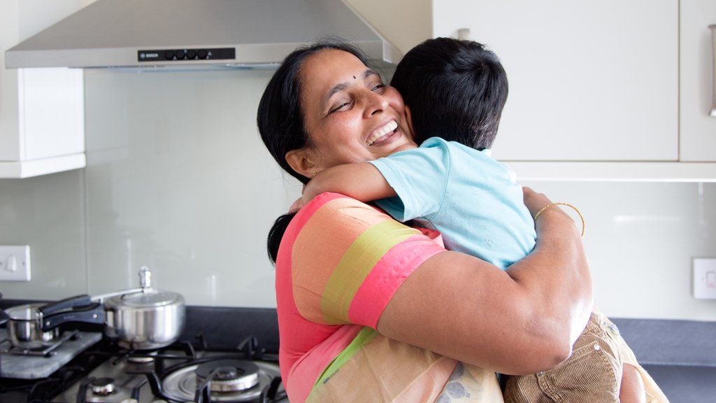 Woman in saree hugging her grandchild