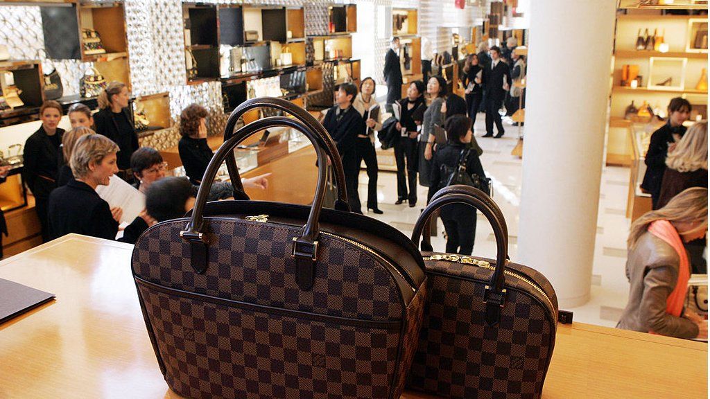 Kanye West leaving his office in a red and blue checkered jacket and  carrying a large Louis Vuitton luggage bag Featuring: Kany Stock Photo -  Alamy