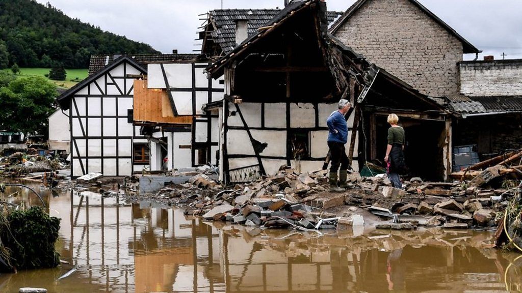 Residents inspect collapsed houses in Schuld, Germany, 15 July 2021