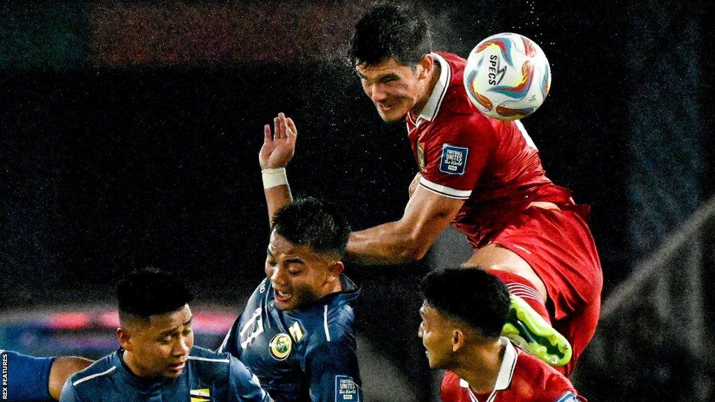 Elkan Baggott wins an aerial challenge in a qualifying game against Brunei