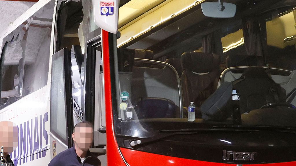 A close-up of the Lyon team coach shows damage to some of the windows