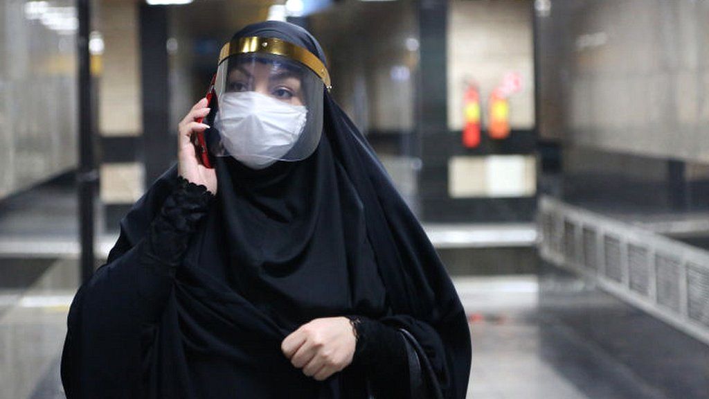 Woman with mask and phone in Tehran