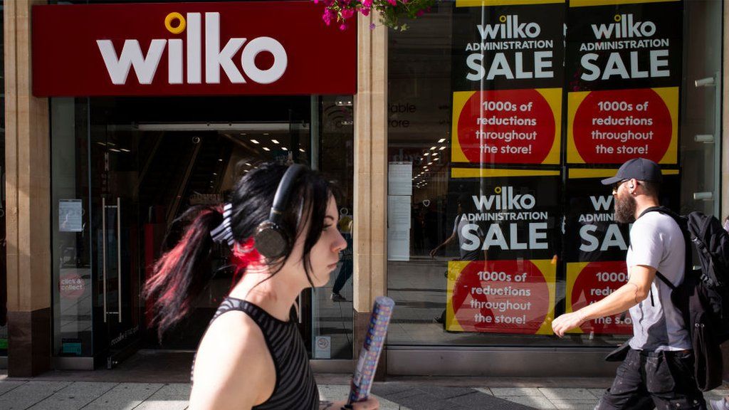 Woman walks by Wilko storefront