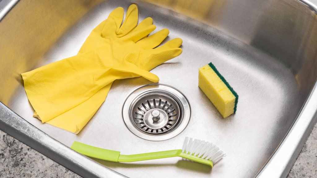 Kitchen sink with rubber gloves, a brush and sponge