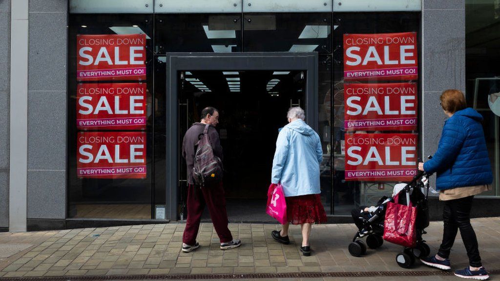 People enter a shop advertising a closing down sale in Leeds, United Kingdom.