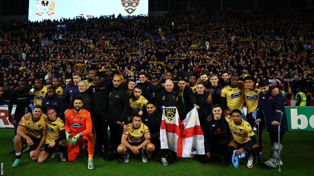 Maidstone's players and staff posed in front of their fans at the end of their FA Cup run