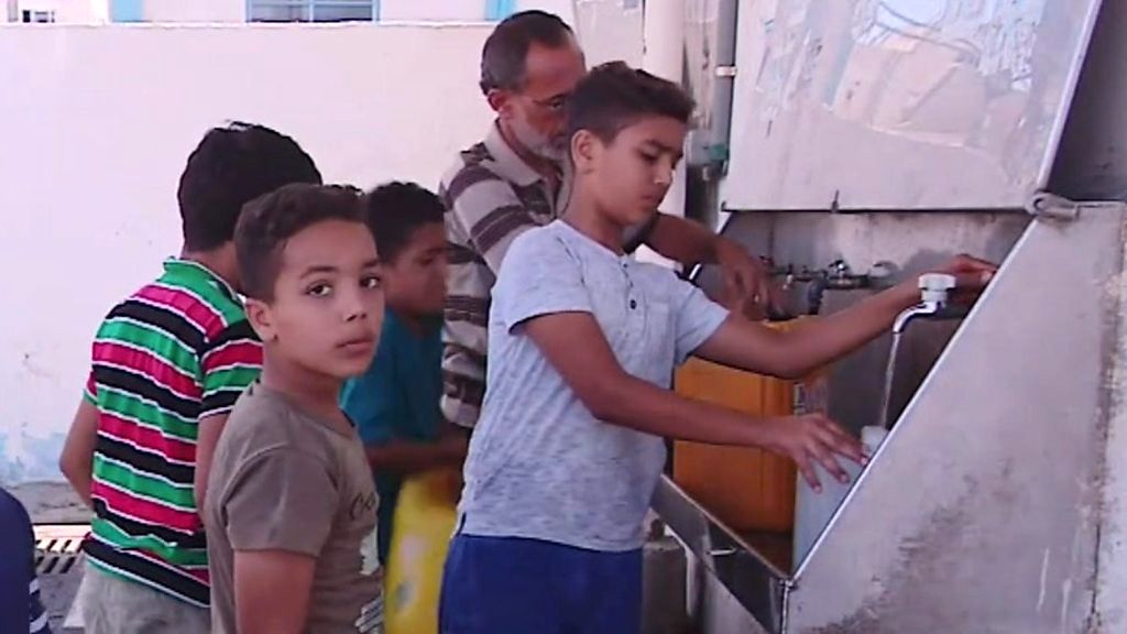 Children in Gaza get water from a communal supply