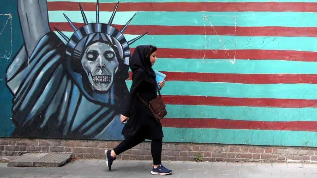 A woman passes a mural painted on the wall of the former US Embassy in Tehran, Iran, on 9 May 2018