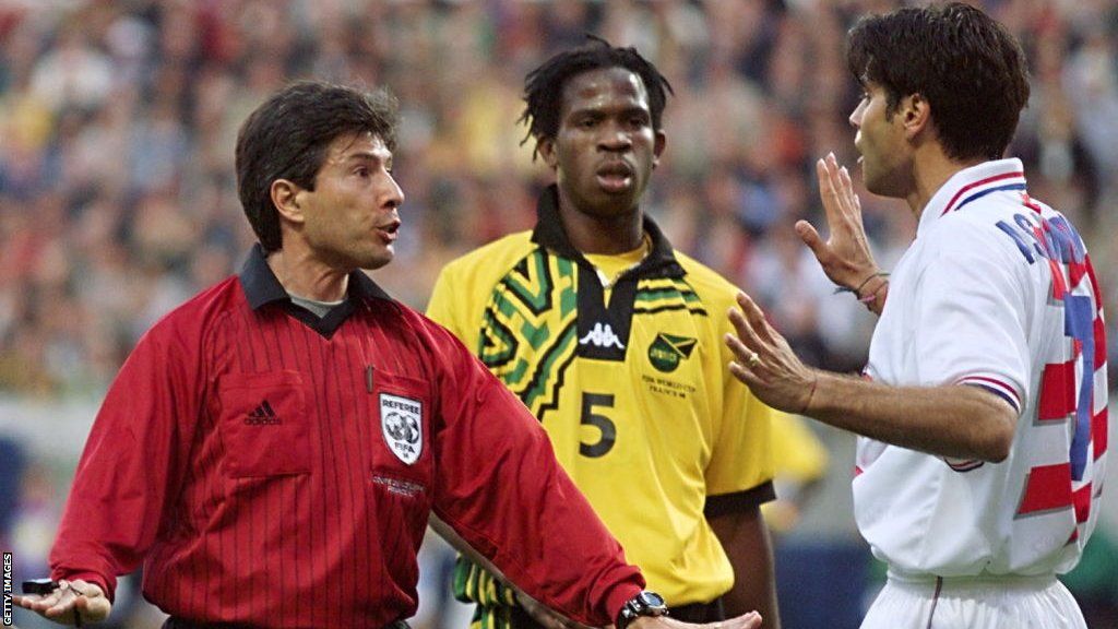 Referee Vitor Manuel Melo Pereira speaks to Croatia's Aljosa Asanovic during a game at the 1998 World Cup, watched by Jamaica's Ian Goodison