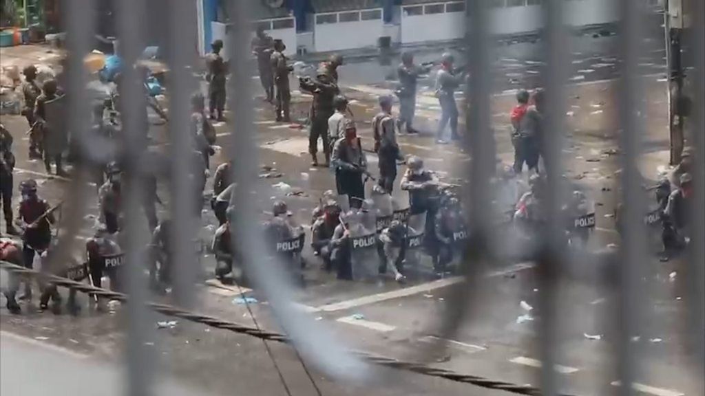 Shot of police in the street with guns and shields