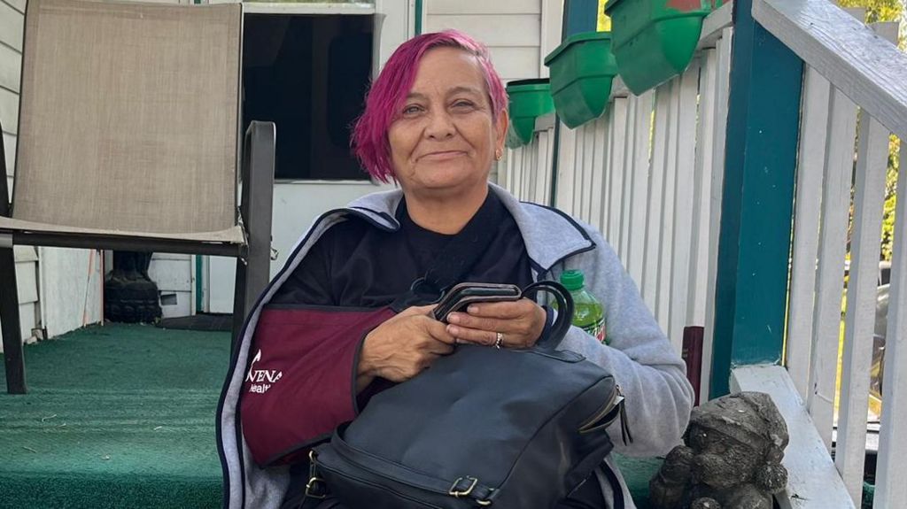 Rachel Oviedo, 57, sits on her porch