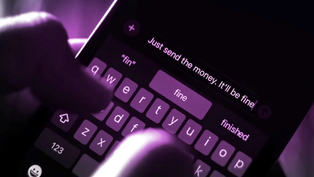A close up of fingers typing on a smart phone with the words 'Just send the money. It'll be fine' shown on the phone's screen. The photo has been tinted purple.  