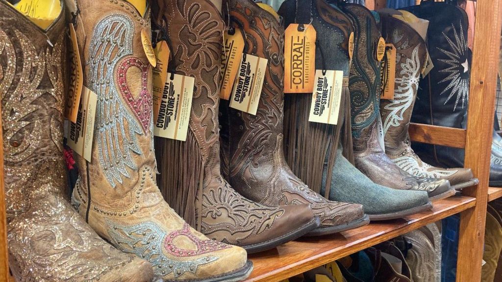 A row of highly decorated cowboy boots on a shop shelf