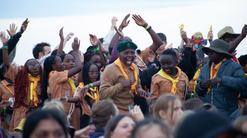 Guides and scouts from Kenya dancing and smiling at a jamboree