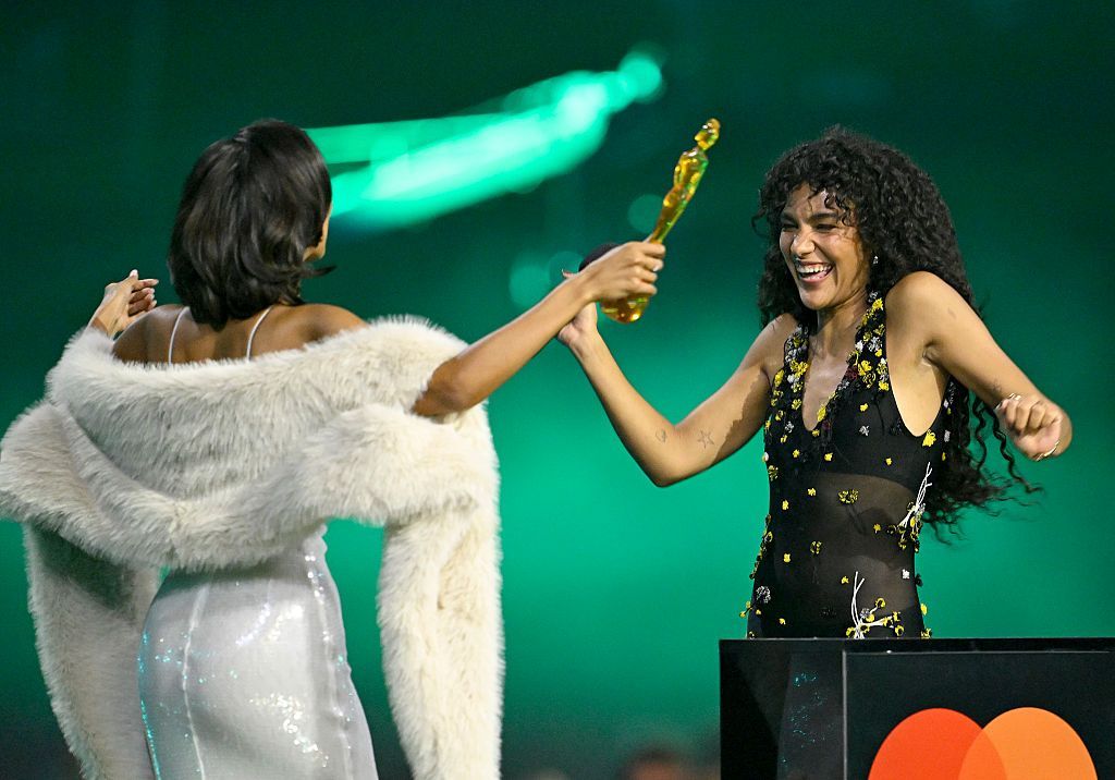 Olivia Dean dances up to Maya Jama as she collects her award. 